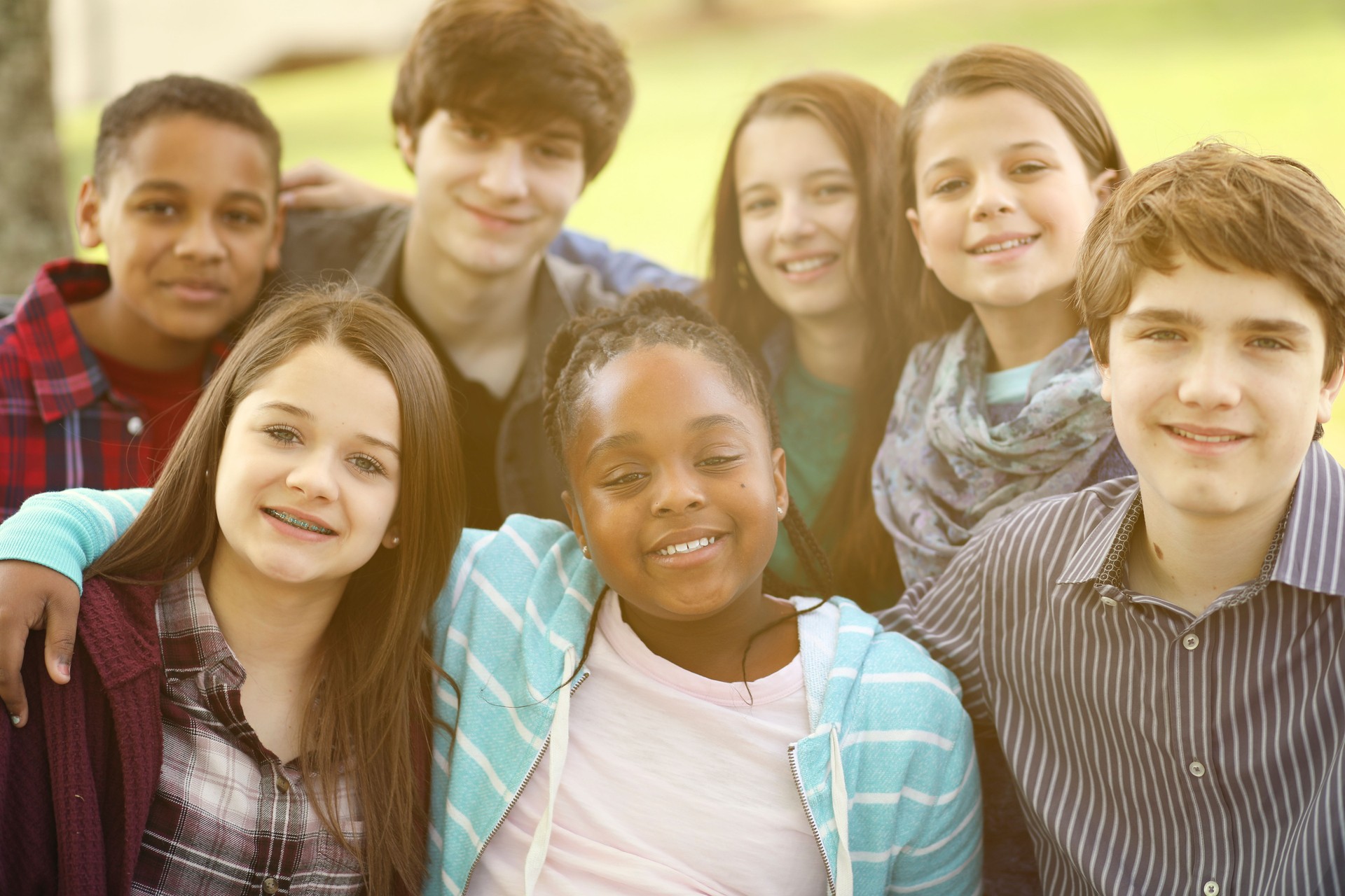 Multi-ethnic group of teenagers at park with friends.