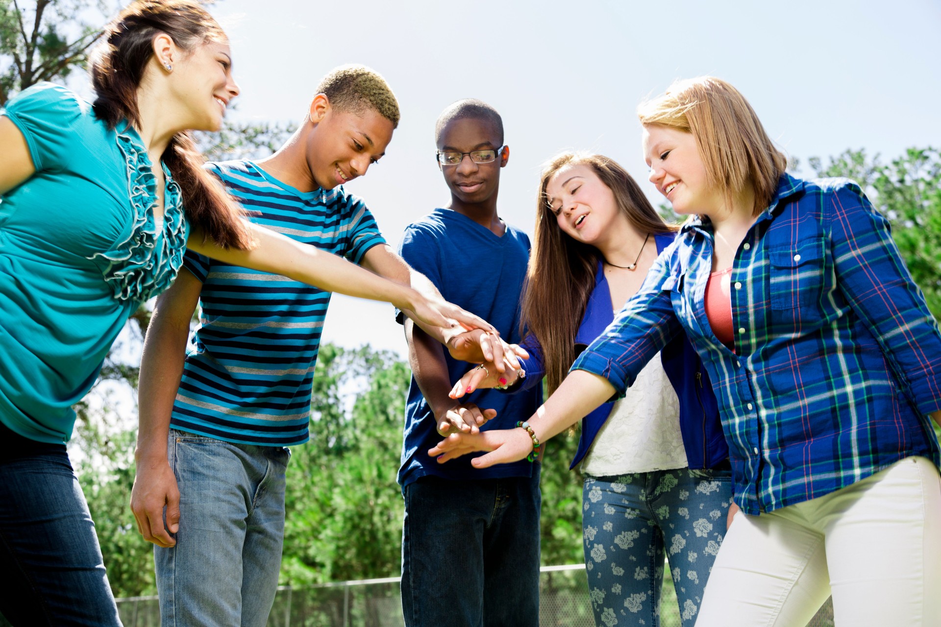 All for one! Teens showing unity, a helping hand.